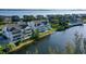 Scenic aerial view of waterfront townhomes with screened lanais and lush landscape with Gulf of Mexico backdrop at 111 Tidy Island Blvd # 111, Bradenton, FL 34210
