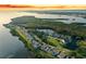 Breathtaking aerial view of waterfront homes with lush greenery and tranquil bay, highlighted at sunset at 111 Tidy Island Blvd # 111, Bradenton, FL 34210