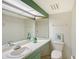 Bright half bathroom featuring a modern vanity with framed mirror, decorative accents, and an elongated toilet at 111 Tidy Island Blvd # 111, Bradenton, FL 34210