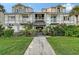 Charming condo building featuring well-maintained landscaping, a paved walkway, and beautiful flowering bushes at 111 Tidy Island Blvd # 111, Bradenton, FL 34210