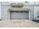 Attached grey garage with an arched entrance and grey concrete driveway at 111 Tidy Island Blvd # 111, Bradenton, FL 34210