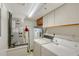 Functional laundry room featuring a washer, dryer, water heater, utility sink, and cabinet storage space at 111 Tidy Island Blvd # 111, Bradenton, FL 34210