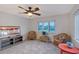 A well-lit living room with a window view, wicker seating, ceiling fan, and neutral carpet at 111 Tidy Island Blvd # 111, Bradenton, FL 34210