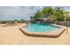 Community pool and hot tub featuring a brick-paved deck, surrounded by tropical landscaping and beautiful scenery at 111 Tidy Island Blvd # 111, Bradenton, FL 34210