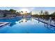 Gorgeous, sparkling pool reflecting the sunset, palm trees, and gazebo, set against a clear sky at 111 Tidy Island Blvd # 111, Bradenton, FL 34210