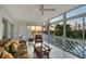 Inviting sunroom filled with natural light, showcasing wicker furniture and serene water views, perfect for relaxation at 111 Tidy Island Blvd # 111, Bradenton, FL 34210