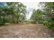 Expansive backyard showcasing mature trees, landscaping, and a screened in lanai and pool area; perfect for outdoor living at 1143 131St E St, Bradenton, FL 34212