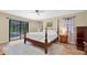 This bedroom features a four poster bed, ceiling fan, and sliding door to the pool at 1143 131St E St, Bradenton, FL 34212