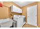 Functional laundry room features a utility sink, washer, dryer, and convenient overhead storage cabinets at 1143 131St E St, Bradenton, FL 34212