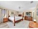 Main bedroom features four-poster bed, neutral walls, and modern ceiling fan at 1143 131St E St, Bradenton, FL 34212