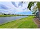 Beautiful waterfront backyard view with lush green grass, a serene lake, and picturesque neighborhood homes at 12330 Halfmoon Lake Ter, Bradenton, FL 34211