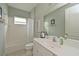 Bathroom with a shower-tub combo, framed mirror, white tile and vanity at 12330 Halfmoon Lake Ter, Bradenton, FL 34211