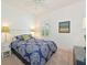 Well-lit bedroom featuring a patterned comforter, shuttered window, and neutral carpeting at 12330 Halfmoon Lake Ter, Bradenton, FL 34211