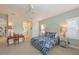 Bright bedroom with a blue patterned bedspread, plantation shutters, and an ensuite bath at 12330 Halfmoon Lake Ter, Bradenton, FL 34211