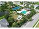 Aerial view showcasing tennis court, pool, playground, and pond of the neighborhood amenities at 12330 Halfmoon Lake Ter, Bradenton, FL 34211