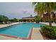 Community pool showcasing lounge chairs, covered seating, and lush greenery, ideal for relaxing and socializing at 12330 Halfmoon Lake Ter, Bradenton, FL 34211
