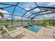 Inviting screened-in pool with waterfall features and picturesque lake views at 12330 Halfmoon Lake Ter, Bradenton, FL 34211