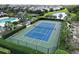 Aerial view of a community tennis court showcasing the court, landscaping, and surrounding neighborhood homes at 12330 Halfmoon Lake Ter, Bradenton, FL 34211