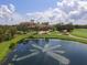 Scenic aerial view of the country club, framed by a pond with a fountain and a pristine golf course at 12516 Thornhill Ct, Lakewood Ranch, FL 34202