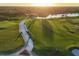 Aerial view of a pristine golf course with golf carts lining the cart path at sunset at 12516 Thornhill Ct, Lakewood Ranch, FL 34202