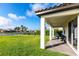 Lush backyard with a covered patio, landscaping, and a view of the lake at 13422 Flat Woods Ter, Bradenton, FL 34211