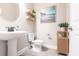 Charming powder room with a pedestal sink, decorative shelves, and stylish wall art for a cozy ambiance at 13422 Flat Woods Ter, Bradenton, FL 34211