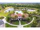 Stunning aerial view of the community pool and clubhouse, surrounded by lush landscaping and serene water features at 13422 Flat Woods Ter, Bradenton, FL 34211