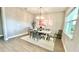Elegant dining room with wood floors, modern chandelier, area rug, and a sunlit window at 13422 Flat Woods Ter, Bradenton, FL 34211