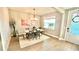 Elegant dining room with wood floors, modern chandelier, area rug, and access to the front entrance at 13422 Flat Woods Ter, Bradenton, FL 34211
