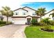 Inviting two-story home featuring a beautiful brick driveway, a two-car garage, and lush landscaping at 13422 Flat Woods Ter, Bradenton, FL 34211