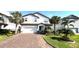 Charming two-story home with a brick driveway, lush landscaping, and a two-car garage at 13422 Flat Woods Ter, Bradenton, FL 34211
