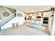 A spacious kitchen with a large island, pendant lighting, and adjacent staircase at 13422 Flat Woods Ter, Bradenton, FL 34211