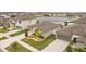 Aerial view shows a single-Gathering house with a manicured lawn, two-car garage, and neighboring houses near a pond at 13422 Willow Bluestar Loop, Riverview, FL 33579