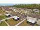 Aerial view of multiple roofs in a neighborhood featuring a pond and lush green trees on a sunny day at 13422 Willow Bluestar Loop, Riverview, FL 33579