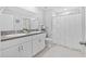 Modern bathroom with double sinks, granite countertops, white cabinets, and a walk-in shower with a curtain at 13422 Willow Bluestar Loop, Riverview, FL 33579