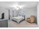 Relaxing bedroom features a ceiling fan, neutral colors, carpet, and an art piece over the bed at 13422 Willow Bluestar Loop, Riverview, FL 33579