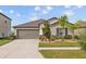 Charming single-story home with a well-maintained lawn and a two car garage on a sunny day at 13422 Willow Bluestar Loop, Riverview, FL 33579