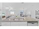 A kitchen island features a stainless steel sink with an open view to the living and dining areas at 13422 Willow Bluestar Loop, Riverview, FL 33579