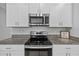 Close up of kitchen showing stainless steel appliances, granite counters, and white cabinetry at 13422 Willow Bluestar Loop, Riverview, FL 33579