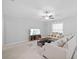 Bright living room featuring a ceiling fan and large window for natural light at 13422 Willow Bluestar Loop, Riverview, FL 33579