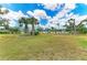 Beautiful backyard with manicured lawn, mature trees, and privacy fence at 1364 Westport Ln # 1403, Sarasota, FL 34232