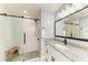 Beautiful bathroom featuring stone counters, vanity, walk-in shower with glass door, and stone floor at 1364 Westport Ln # 1403, Sarasota, FL 34232