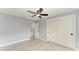 Spacious bedroom featuring a ceiling fan, ensuite bath, wood look tile floors, and large closet at 1364 Westport Ln # 1403, Sarasota, FL 34232