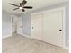 Spacious bedroom featuring a ceiling fan, ensuite bath, wood look tile floors, and large closet at 1364 Westport Ln # 1403, Sarasota, FL 34232