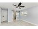 Charming bedroom featuring modern sliding barn door to bathroom, light blue walls, and contemporary ceiling fan at 1364 Westport Ln # 1403, Sarasota, FL 34232