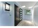 Modern entryway features a stylish black door with glass inserts, light blue walls, and a tile floor at 1364 Westport Ln # 1403, Sarasota, FL 34232