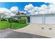 Charming home featuring lush landscaping, a blue exterior, a paved drive leading to the one-car garage at 1364 Westport Ln # 1403, Sarasota, FL 34232