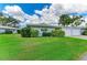 Charming single-story home featuring lush green lawn and landscaping, blue exterior, and an attached one-car garage at 1364 Westport Ln # 1403, Sarasota, FL 34232