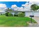 Charming home featuring lush landscaping, a blue exterior, and an attached garage, complemented by a well-maintained lawn at 1364 Westport Ln # 1403, Sarasota, FL 34232