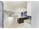 Open-concept kitchen featuring a granite island, modern lighting, and stainless steel appliances, with a view of the sliding glass door at 1364 Westport Ln # 1403, Sarasota, FL 34232